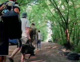 Mobilized men transported in barred bus under armed convoy