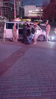 Several TCK employees and police are detaining a man at the bus station